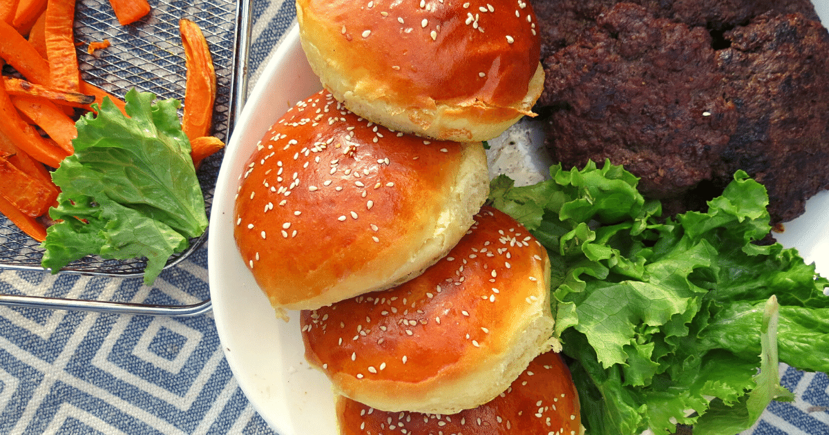 Homemade Hamburger buns on plate with lettuce and hamburgers